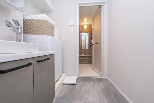 a bathroom with a shower and a sink and a mirror at ZAITO Waseda Terra Hotel in Tokyo