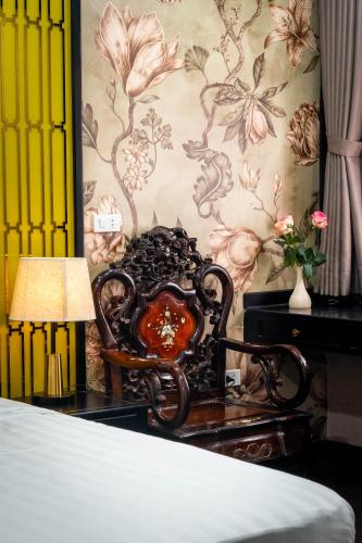 a bedroom with a bed and a table with a lamp at The Dahlia Hotel & Apartments in Hanoi