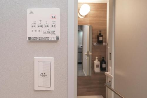 a door with a sign on a wall next to a hallway at ZAITO Waseda Terra Hotel in Tokyo