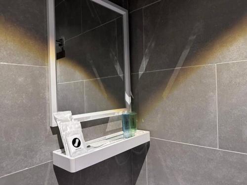a bathroom with a mirror and a soap dispenser at Swing & Pillows - KLIA 1 KLIA 2, Sepang in Sepang