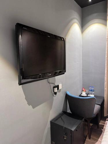 a flat screen tv hanging on a wall at Swing & Pillows - KLIA 1 KLIA 2, Sepang in Sepang