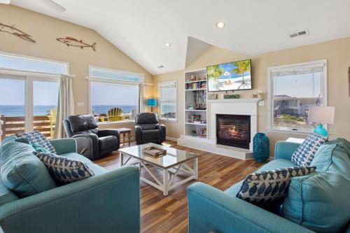 a living room with blue couches and a fireplace at 7081 - Southern Breeze in Nags Head