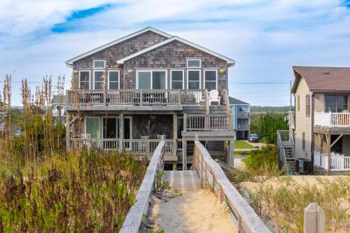 a house with a boardwalk leading to the beach at 7076 - JMJ Seascape in Nags Head
