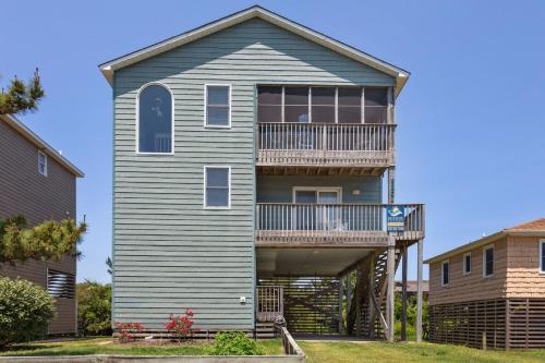 a house with a wrap around porch with a balcony at 7088 - Short II in Grun Island