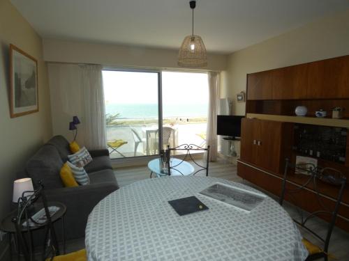 Cet appartement comprend une chambre avec un lit et un salon offrant une vue sur l'océan. dans l'établissement Appartement face océan à Notre-Dame-de-Monts, balcon, parking, animaux OK, accès direct plage - FR-1-540-226, à Notre-Dame-de-Monts