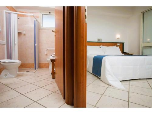 ein Schlafzimmer mit einem Bett und ein Badezimmer mit einer Toilette in der Unterkunft Studio in Scoglitti, Sizilien in Scoglitti