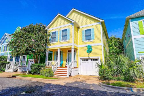 a yellow house with a white garage at BB47 - A Wave From It All in Kill Devil Hills
