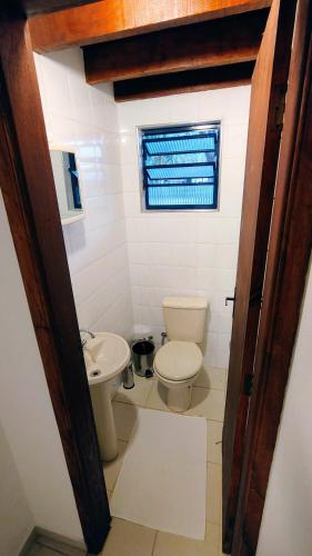 a bathroom with a toilet and a sink at Bangalô no Sítio Cantal in Piracaia