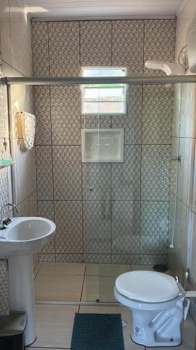 a bathroom with a shower and a toilet and a sink at Casa de Campo Sitio com tranquilidade in Cunha