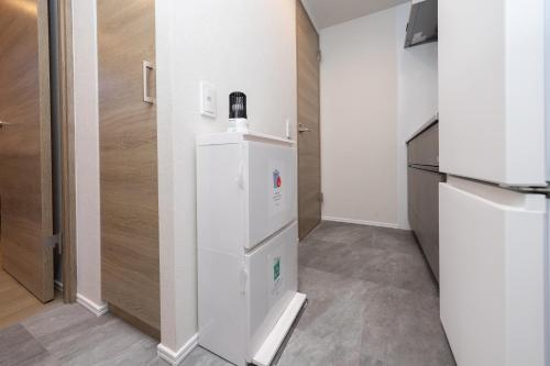 a small kitchen with a white refrigerator and a counter at ZAITO Waseda Terra Hotel in Tokyo