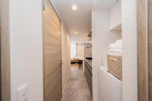a hallway with a door leading to a laundry room with towels at ZAITO Waseda Terra Hotel in Tokyo