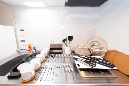 a kitchen with dishes and utensils on a sink at ZAITO Waseda Terra Hotel in Tokyo