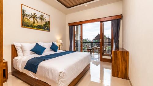 a bedroom with a bed and a balcony at Usana House Ubud in Ubud