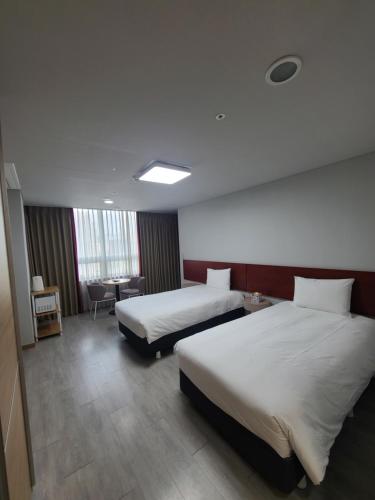 a hotel room with two beds and a desk at Hotel Modak Namdaemun in Seoul