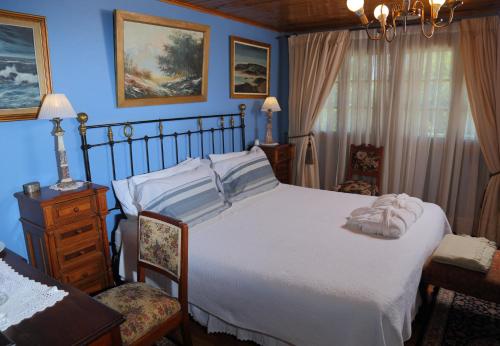 a bedroom with a large white bed and a chair at Boutique Hotel Premium Vendimia in Santa Cruz