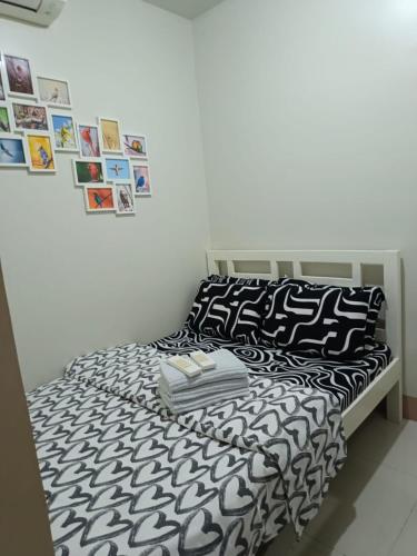 マニラにあるJoRan Staycation 1BR Unit near Moa with Netflixのベッド(白黒の掛け布団、枕付)