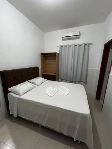 a bedroom with a bed with a bow on it at Pousada Oliveira in Remanso