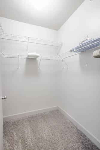 an empty room with white walls and white shelves at CozySuites at the Banks gym pool 03 in Cincinnati