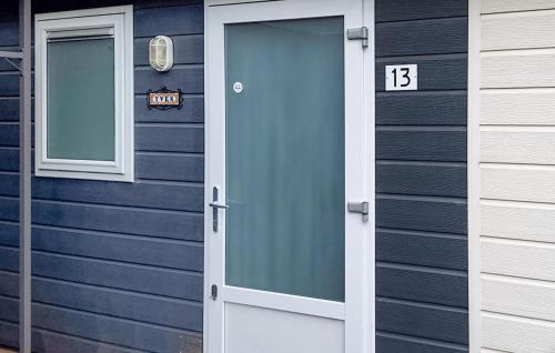 a blue house with a door with the number thirteen at 2 Bedroom Lovely StaCaravan In Vorden in Vorden