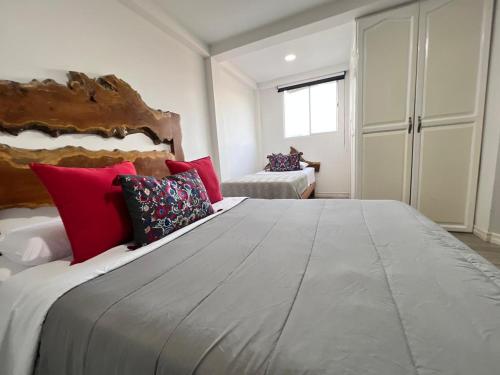 a bedroom with a large bed with red pillows at Casa Hotel Alicia Filandia in Filandia