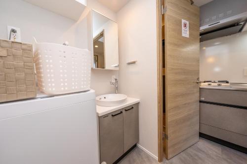 a small bathroom with a sink and a toilet at ZAITO Waseda Terra Hotel in Tokyo