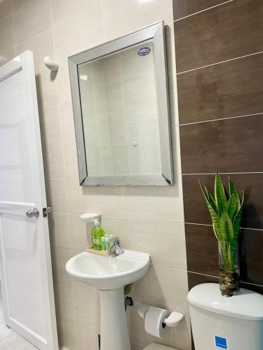 a bathroom with a sink and a toilet and a mirror at Apartahotel MKS Caribe in San Andrés