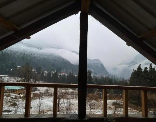 a view of a snowy mountain from a window at Woodstock in Kalgha
