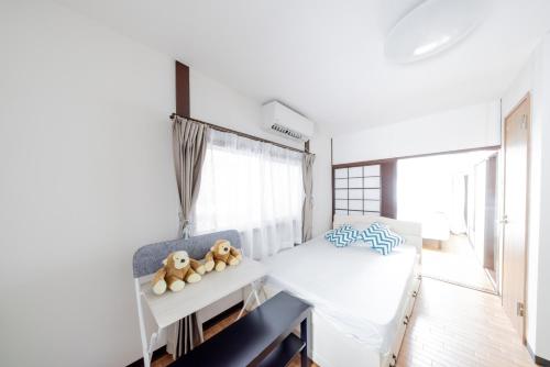 a bedroom with a bed with teddy bears on a shelf at Yoshidokulnn7吉德家庭旅馆7 Near USJ Universal Studios Ocean Food Osaka Castle Park Soraniwa Sauce Hot Spring関西スーパ前独棟-近UsJ-空庭菓匠溫泉-海游館-大阪城公園關西空港直達 in Osaka