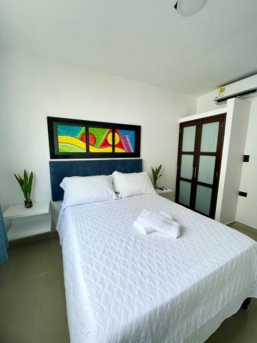 a bedroom with a white bed with a stained glass window at Apartahotel MKS Caribe in San Andrés