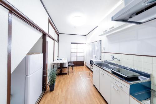a kitchen with a sink and a refrigerator at Yoshidokulnn7吉德家庭旅馆7 Near USJ Universal Studios Ocean Food Osaka Castle Park Soraniwa Sauce Hot Spring関西スーパ前独棟-近UsJ-空庭菓匠溫泉-海游館-大阪城公園關西空港直達 in Osaka