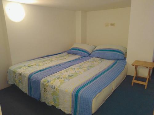a bedroom with a bed with two pillows and a table at Central Residence in Portorož
