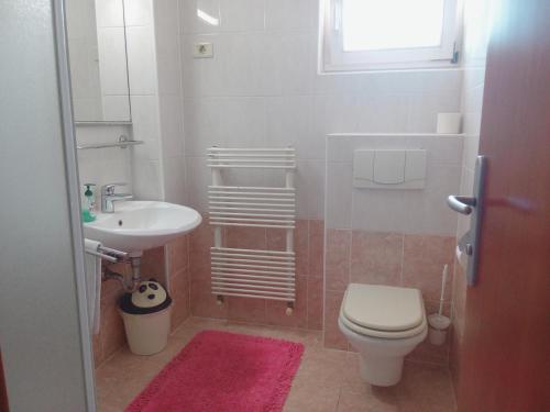 une salle de bain avec toilettes et lavabo dans l'établissement Central Residence, à Portorož