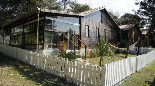 una casa in legno con una staccionata bianca di Chalé em Itu Aconchego e Diversão para Família e Pets a Itu