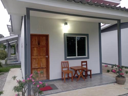 a small house with a table and two chairs at KHUN CHUAT'S HOUSE in Ban Nong Ben