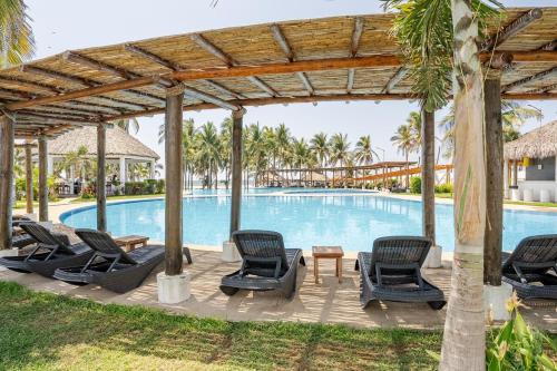 a pool at the resort with chairs and a table at Spacious house with Acapulco club in Acapulco