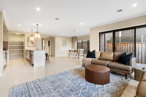 a living room and kitchen with a couch and a table at North Geelong Getaway Modern 4-Bedroom Home in Hamlyn Heights