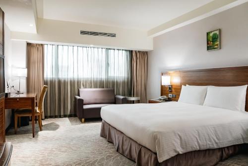 a hotel room with a bed and a desk at Arsma Hotel in Hualien City