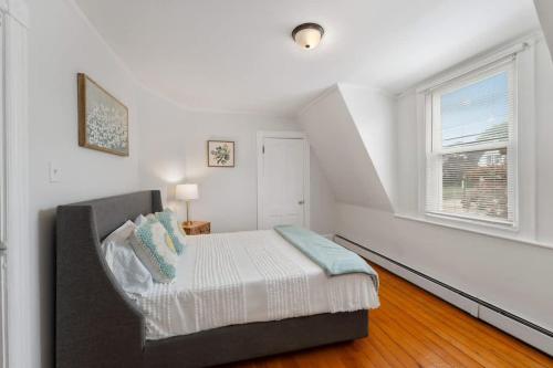a bedroom with a bed and a window at Harbor Walk Charming 4BR Steps to Town & Harbor in Barrington
