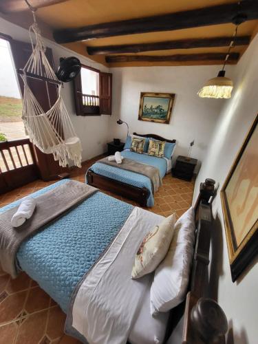 a bedroom with two beds and a hammock in it at AQUI ESTOY BIEN in Barichara