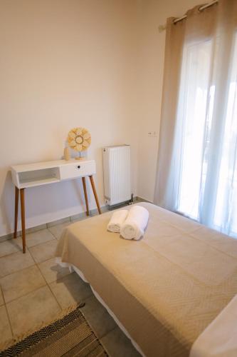 a bedroom with a bed and a desk and a window at EftychiaHouse in Pýrgos