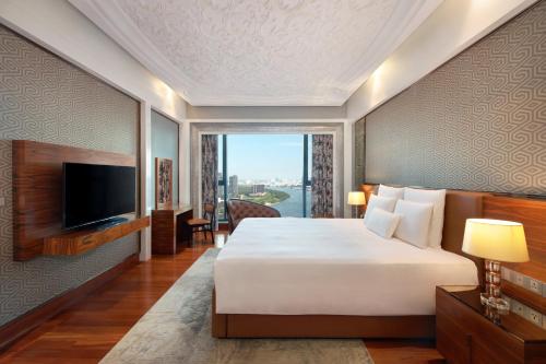 a hotel room with a bed and a television at The Reverie Saigon Residential Suites in Ho Chi Minh City