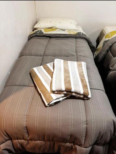 a bed with two towels sitting on top of it at Departamento Parana 2 in Posadas