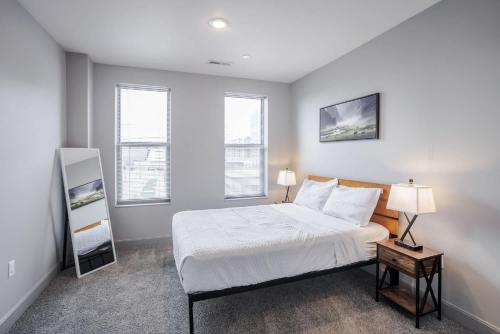 a bedroom with a bed and two windows at CozySuites at the Banks gym pool 12 in Cincinnati