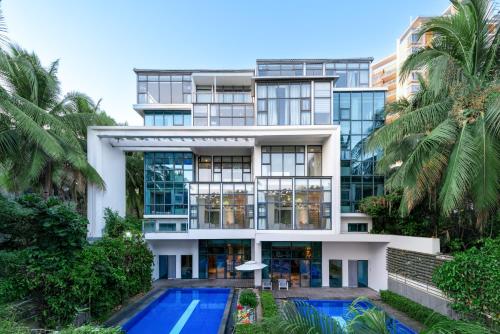 une vue extérieure d'un bâtiment avec piscine dans l'établissement Roy-Sanya Bay Coconut Dream Corridor, à Shuijiao