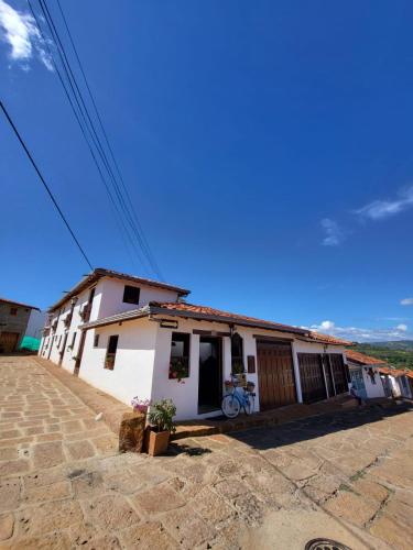 a white house with a bike parked in front of it at AQUI ESTOY BIEN in Barichara