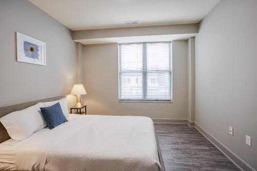 a bedroom with a large white bed and a window at CozySuites at the Banks gym pool 08 in Cincinnati