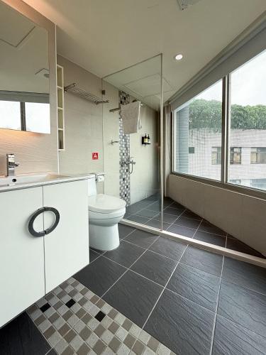 a bathroom with a toilet and a glass shower at 雋格大飯店 Elence Hotel in Taichung