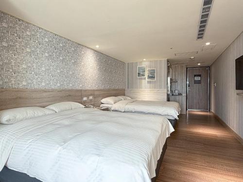 a bedroom with two beds and a wall at 雋格大飯店 Elence Hotel in Taichung