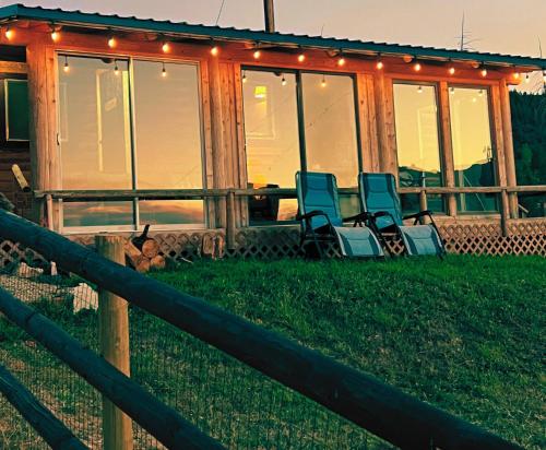 a screened in porch with chairs on the grass at Cozy Cabin Oxen-Le-Fields Montana in Conner