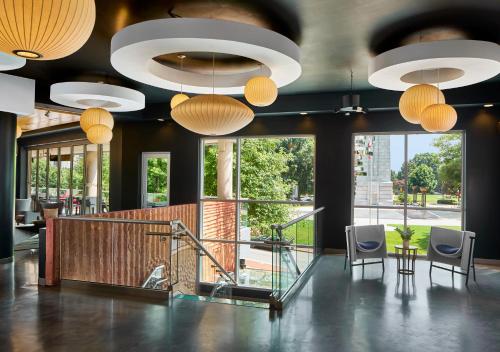 a lobby with tables and chairs and large windows at Aloft Raleigh in Raleigh